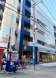 道順6：１階がガラス張りで車が展示してあるショールームビルの３階がエイミー梅田茶屋町店を示す写真