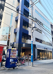 道順8：１階がガラス張りで車が展示してあるショールームビルの３階がエイミー梅田茶屋町店を示す写真